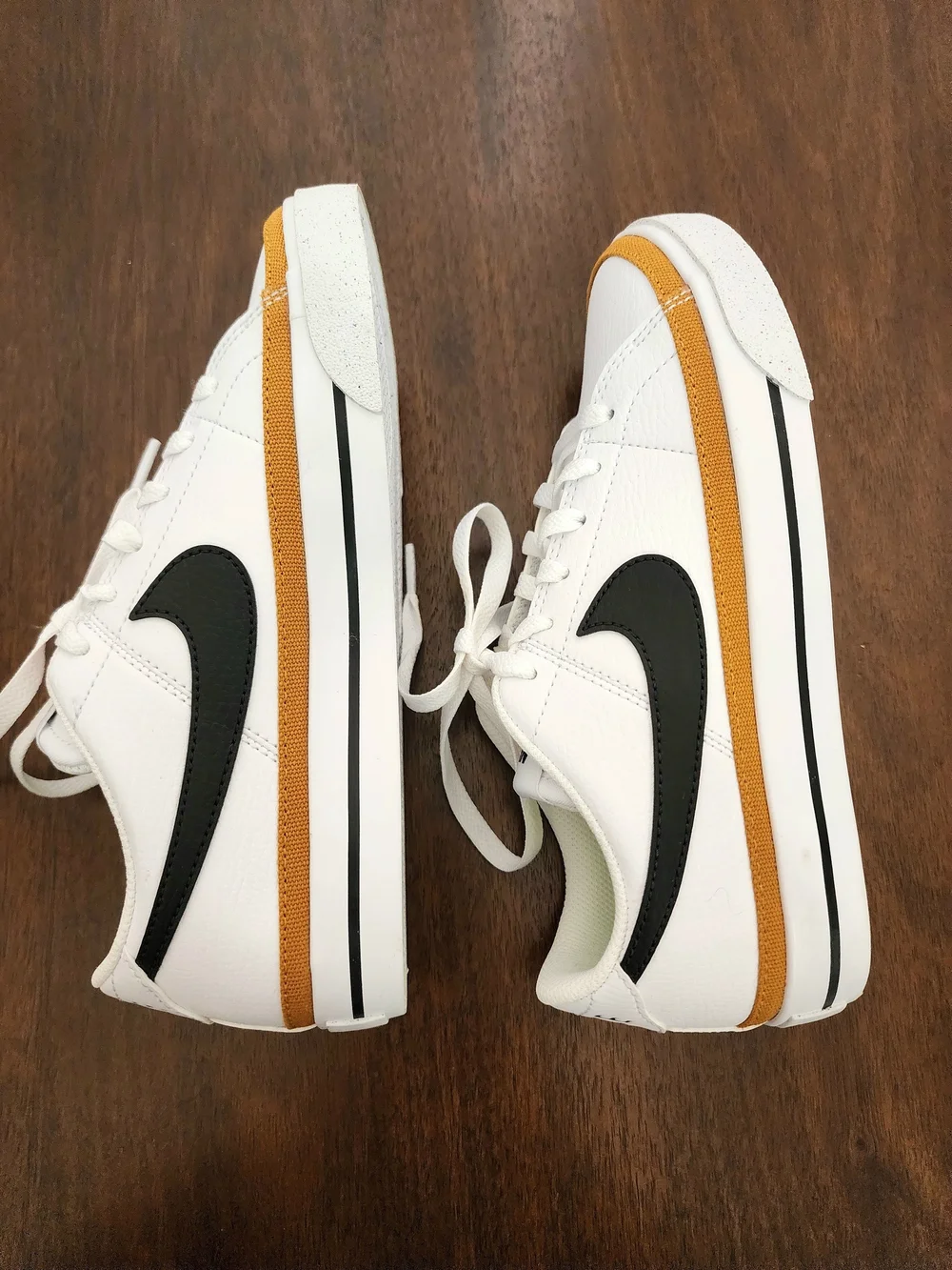 Nike White Low-Top Sneakers with Black Swoosh and Mustard Stripe